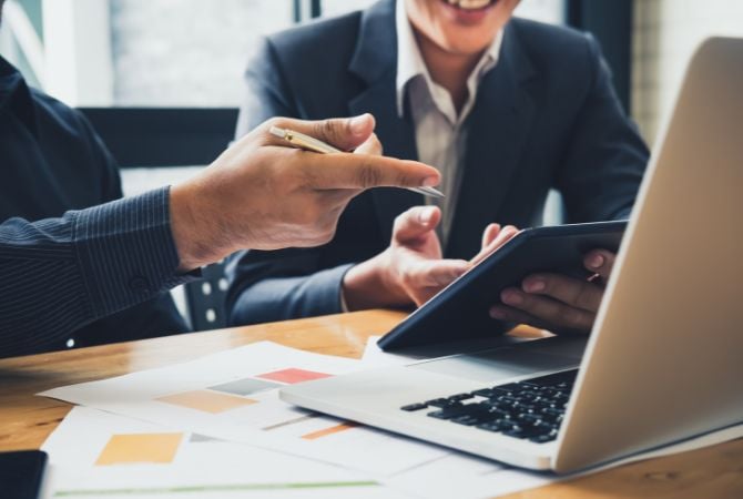 Dos jóvenes trabajando frente a un portatil