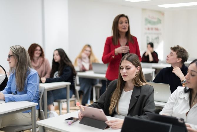 Una clase con profesora y unos estudiantes